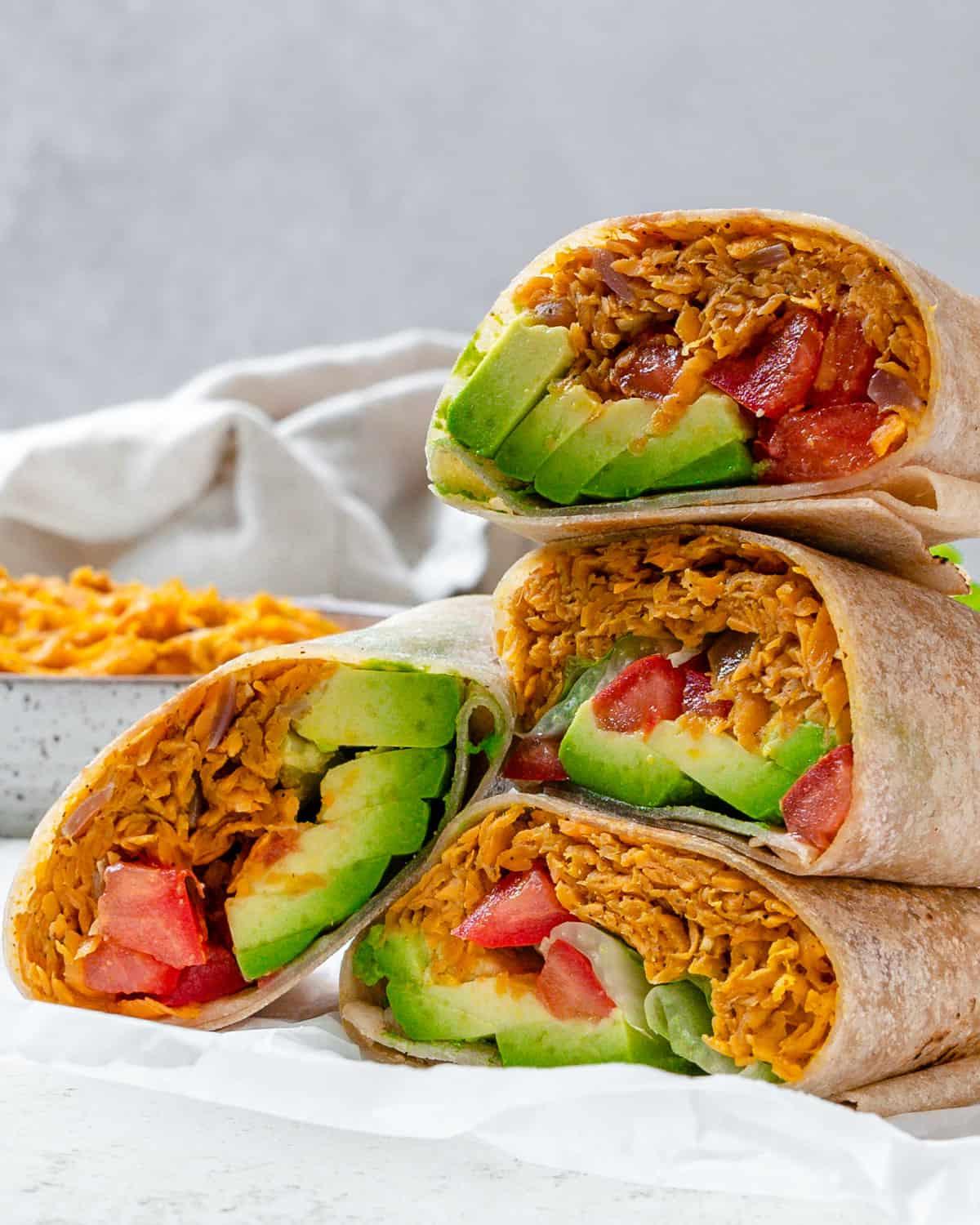 Süßkartoffel-Burritos 2 Fertig gestapelte Süßkartoffel Burritos vor hellem Hintergrund