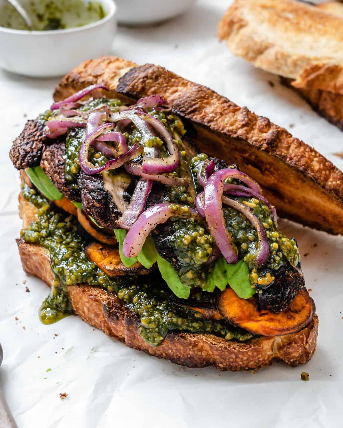 Portobello-Pilz-Sandwich mit Kaffee-Rub 2 Fertiges Portobello-Pilz-Sandwich mit Kaffeewürze auf weißem Untergrund