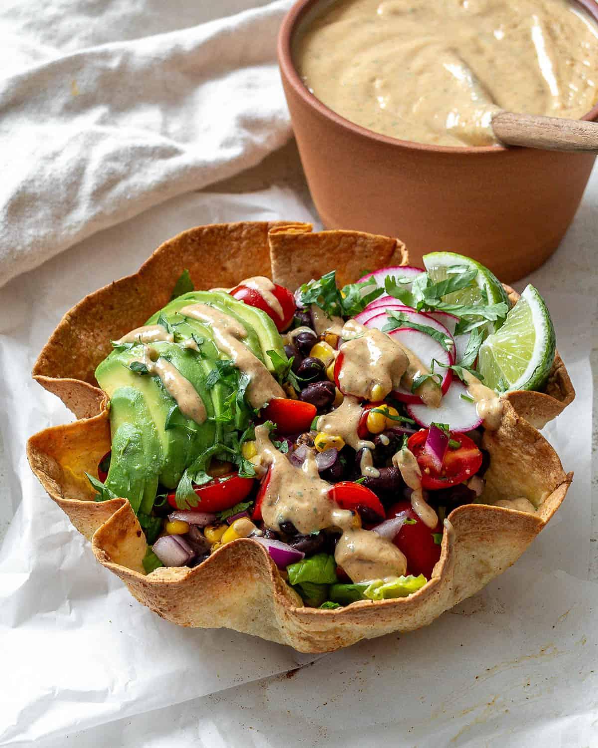 Fertige vegane Chipotle Soße [Taco Salat Dressing] neben einem Taco Salat