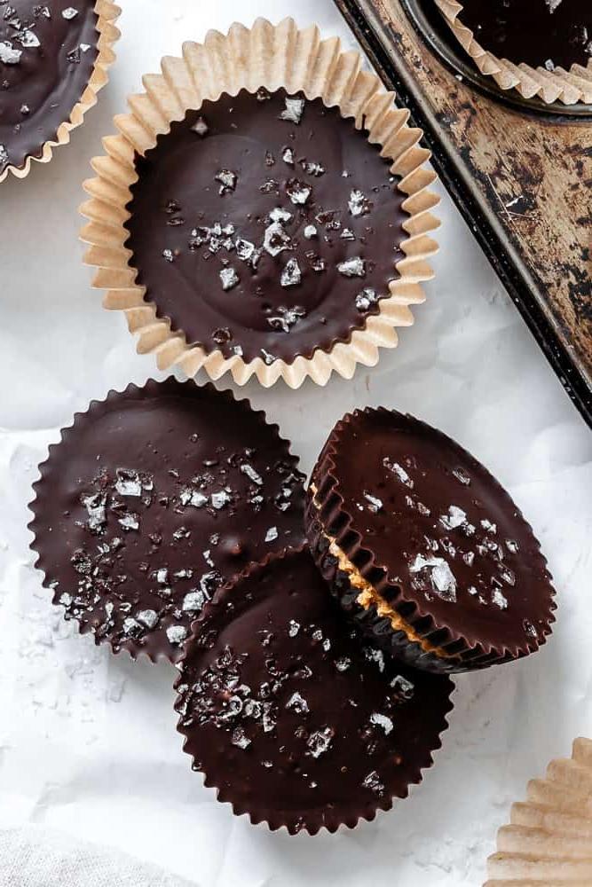 Fertige vegane Erdnussbutter-Cups auf einer weißen Oberfläche.