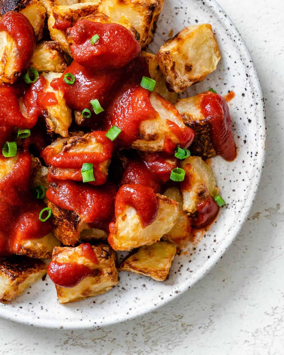 Fertige Patatas Bravas auf einem weißen Teller angerichtet