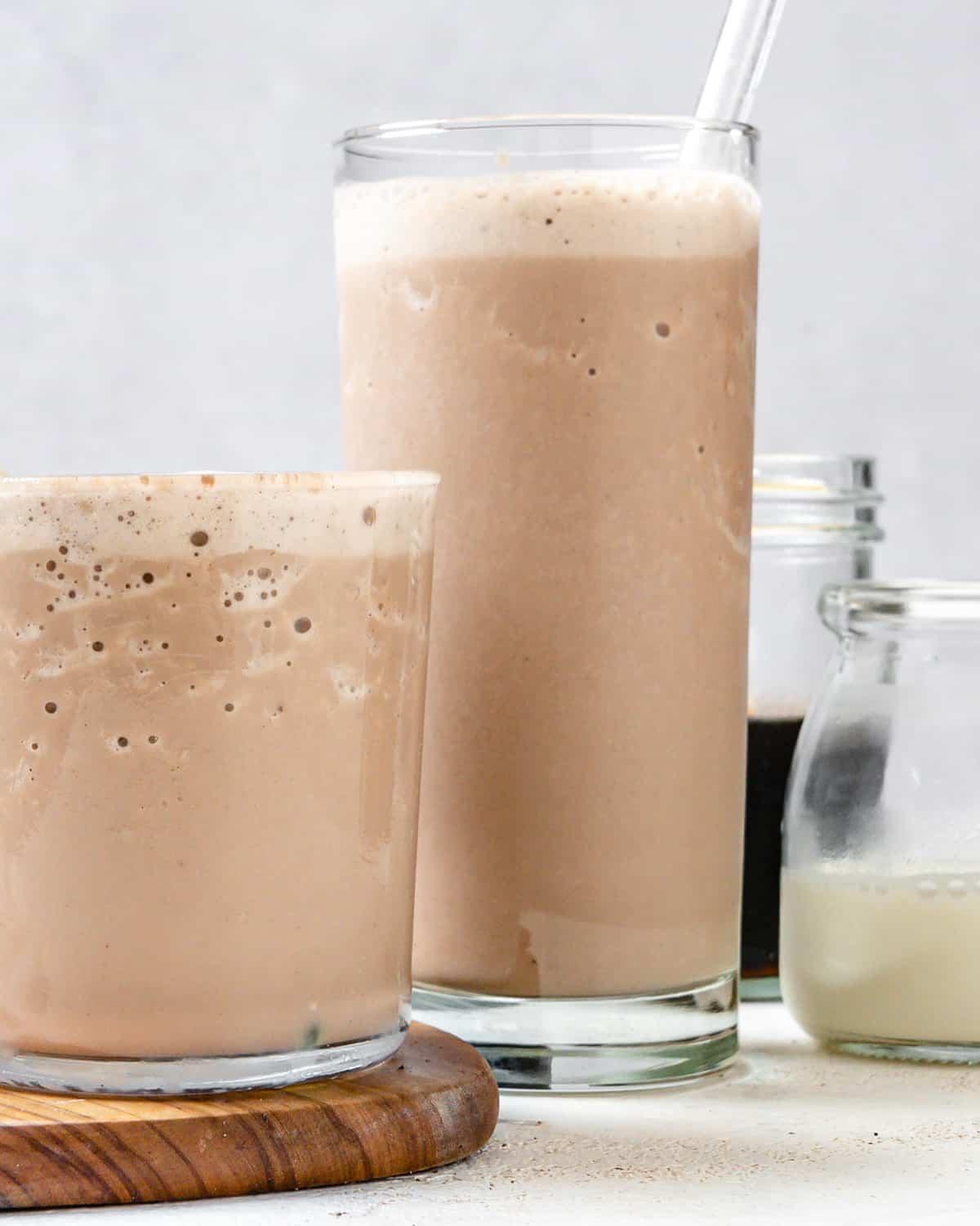 Fertiger Zimt-Hanfsamen-Kaffee-Shake in zwei Gläsern auf hellem Untergrund