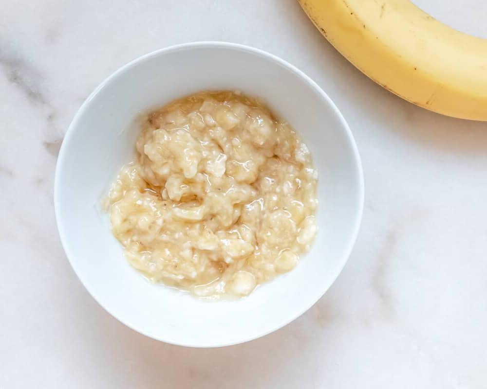 Schale mit zerdrückter Banane und Apfelmus