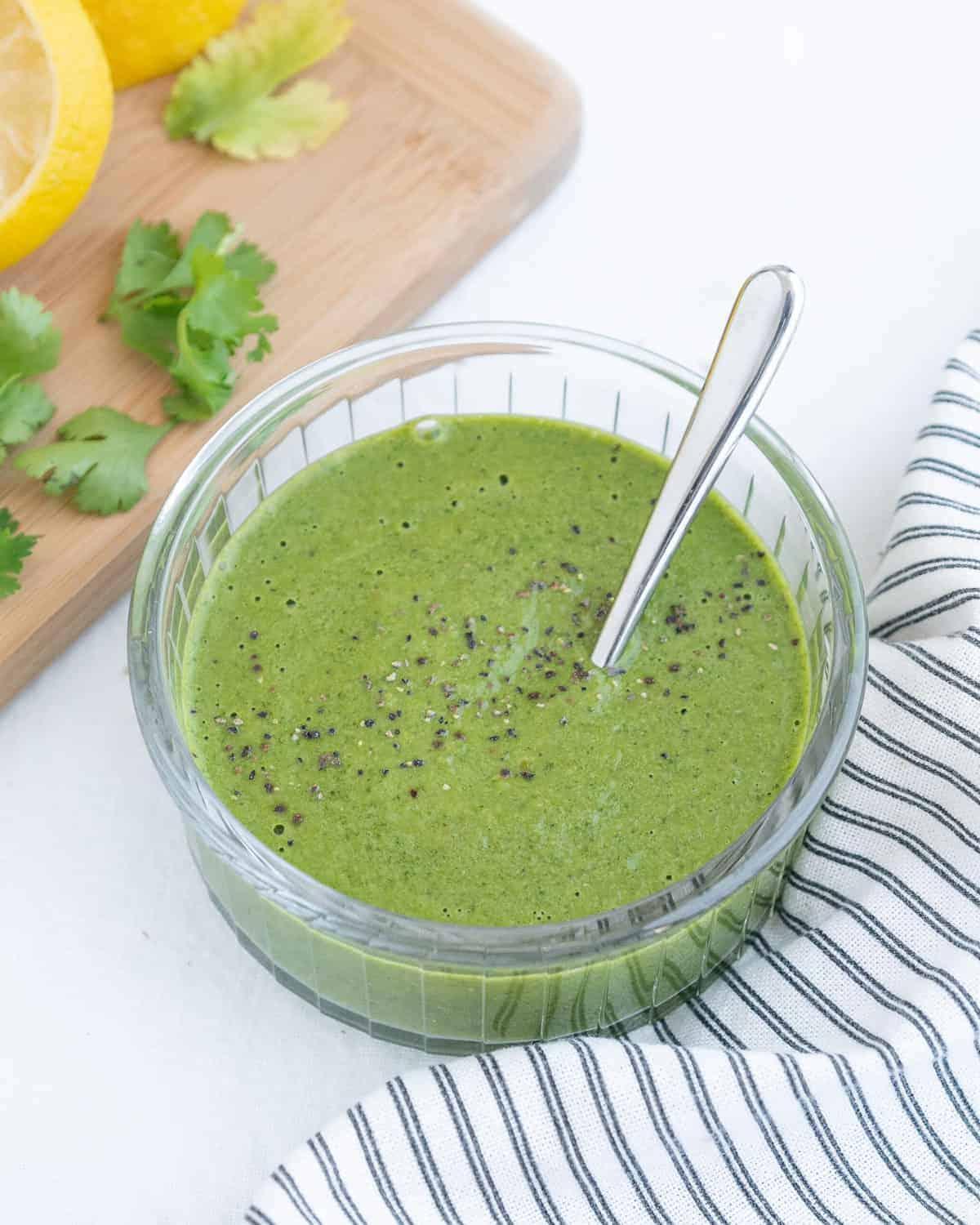 Fertiges Koriander-Grüne-Chili-Dressing in einer Glasschüssel auf weißem Hintergrund