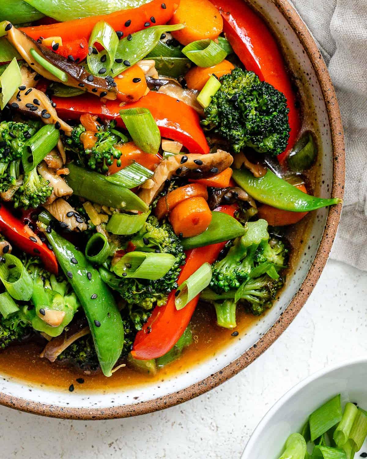 Einfaches Wok-Gemüse 2 Fertiges einfaches Stir-Fry Gemüse in einer Schüssel vor hellem Hintergrund