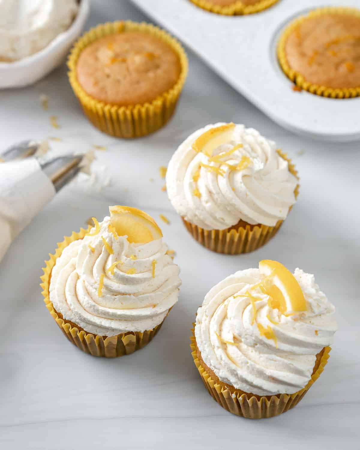 Einfache Vegane Zitronen Cupcakes 2 completed lemon vanilla cupcakes on a white surface