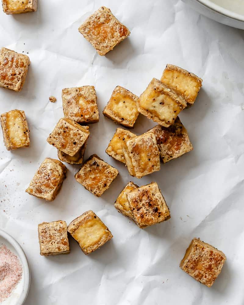 Knuspriger Gebackener Tofu 2 Fertiger knuspriger Back-Tofu auf weißer Oberfläche