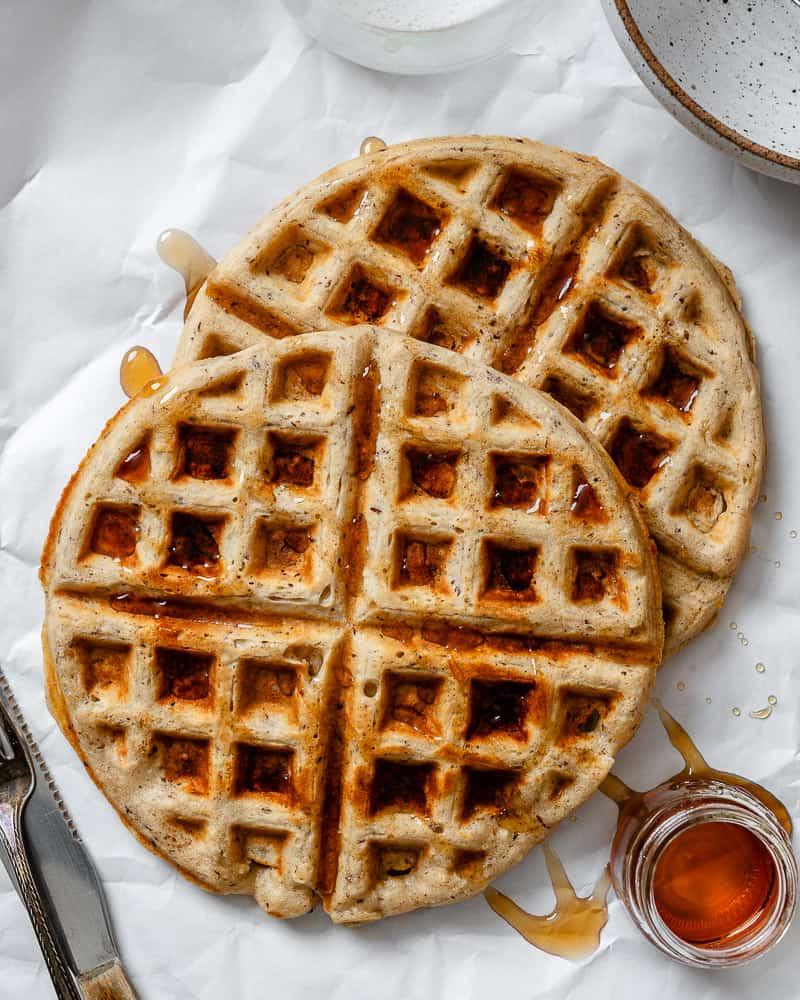 Vegane Waffeln 2 Ein Stapel goldbrauner veganer Waffeln, übergossen mit reichlich Ahornsirup.