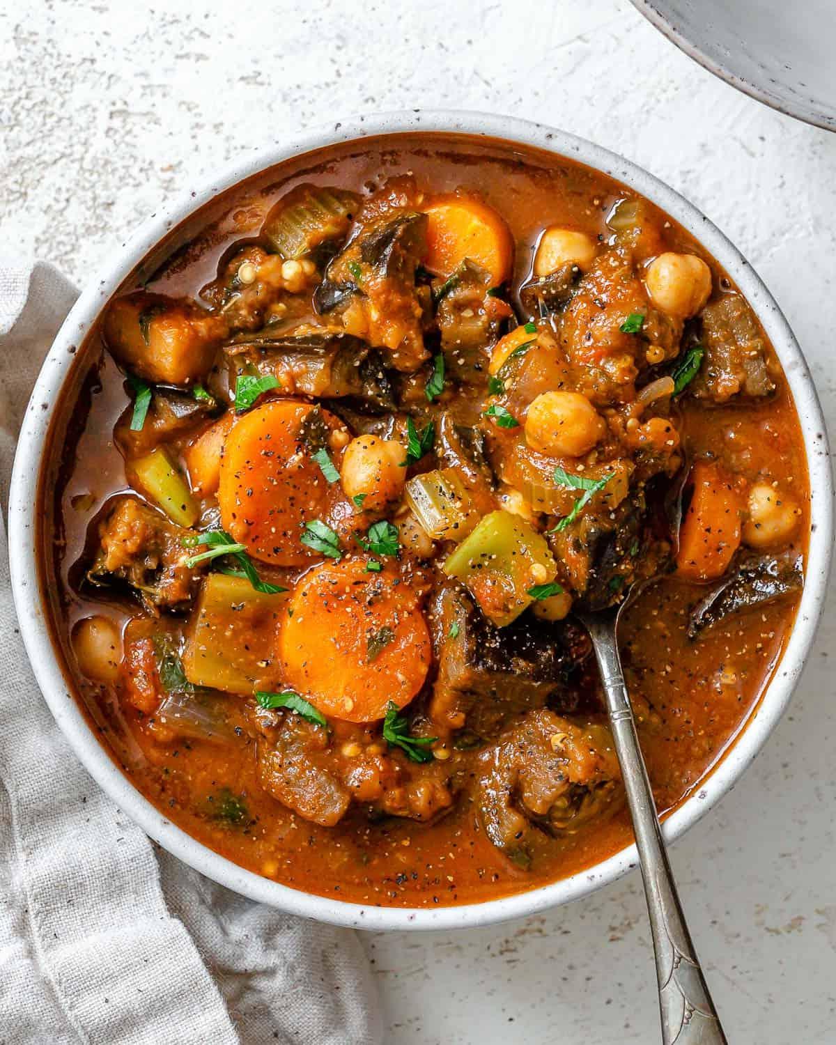 Fertig gestellter Auberginen-Eintopf mit Tomaten und Kichererbsen auf einer weißen Oberfläche