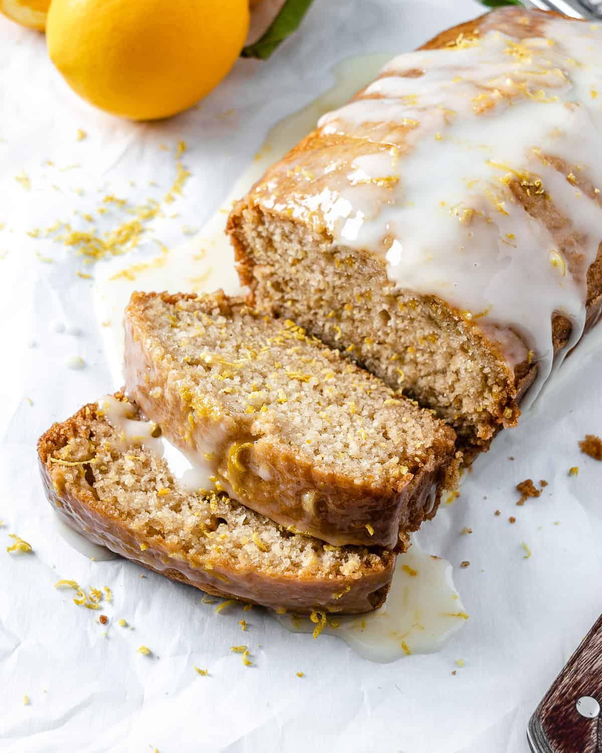Veganer Zitronen-Kastenkuchen 2 Ein aufgeschnittener veganer Zitronenkuchen vor weißem Hintergrund