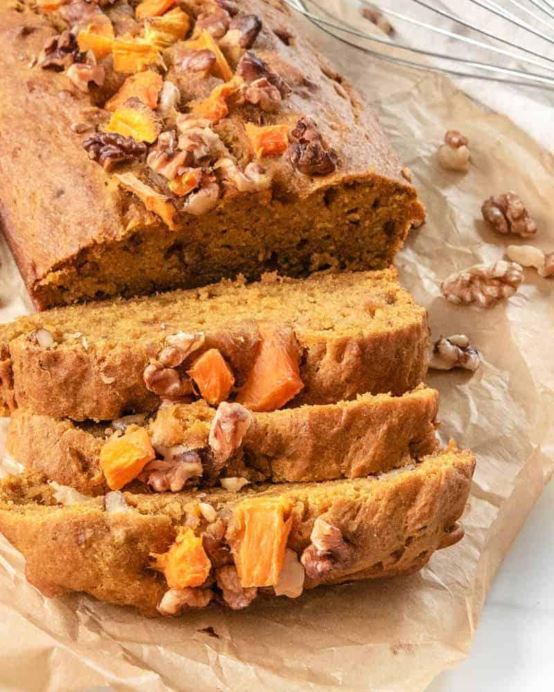 Veganes Kürbisbrot 2 Gebackenes veganes Kürbisbrot in Scheiben auf Backpapier