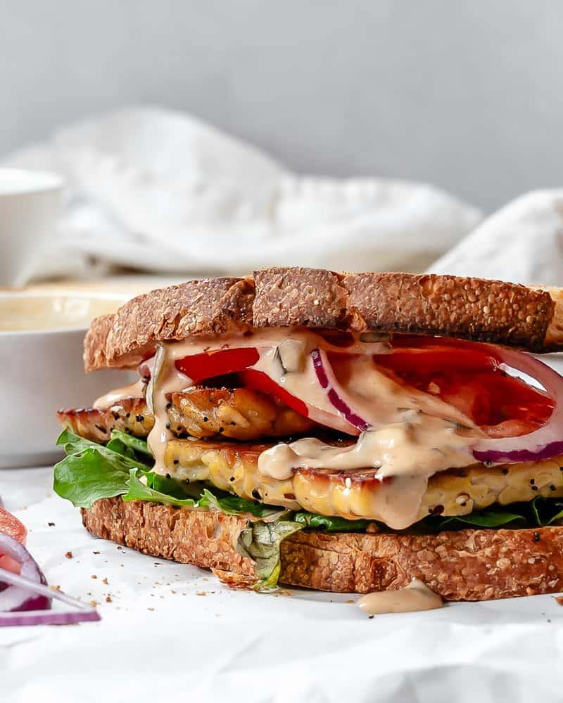 Tempeh-Sandwich 2 Fertiges Tempeh Sandwich auf weißer Oberfläche