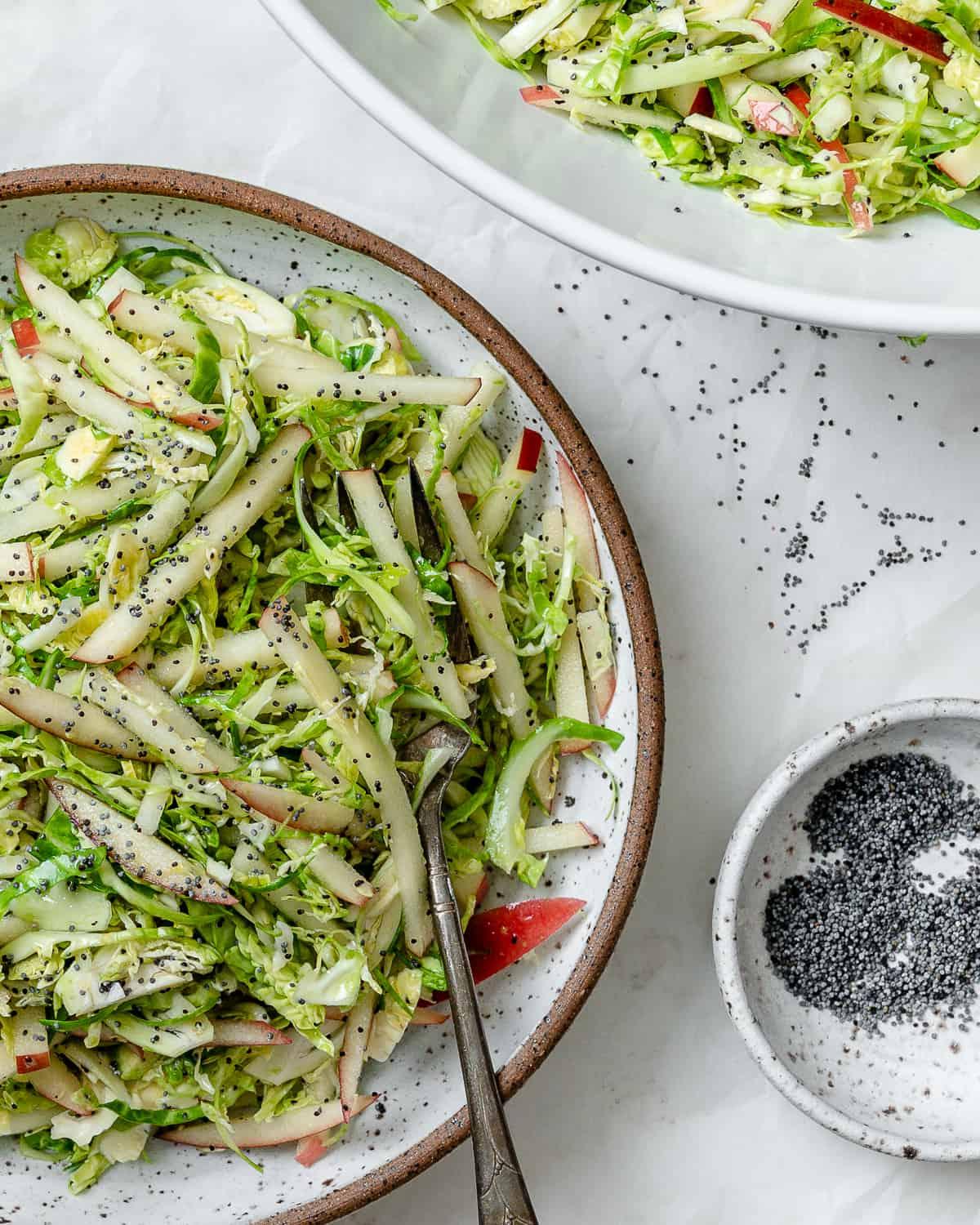 Gehobelter Rosenkohlsalat mit Äpfeln 2 Fertiger Rosenkohl-Krautsalat mit Äpfeln in einer Schüssel