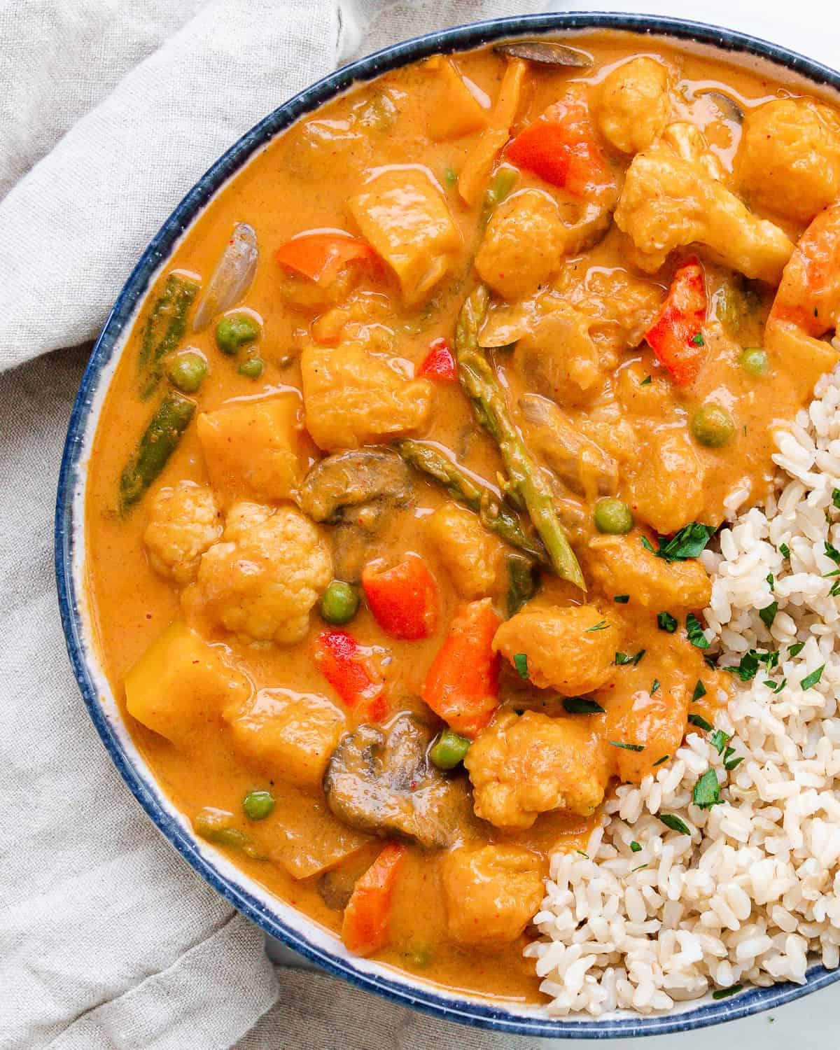 Ein fertiges Butternut-Kürbis-Curry in einer blau gerandeten Schüssel auf hellem Untergrund