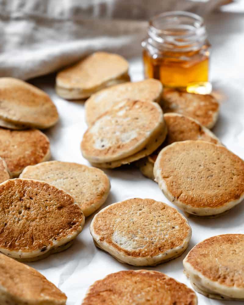 Fertige, fluffige vegane Pfannkuchen in verschiedenen Größen auf einer weißen Oberfläche