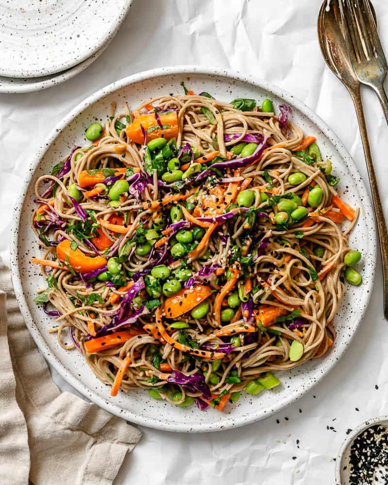soba noodle salad on a large white serving plate.