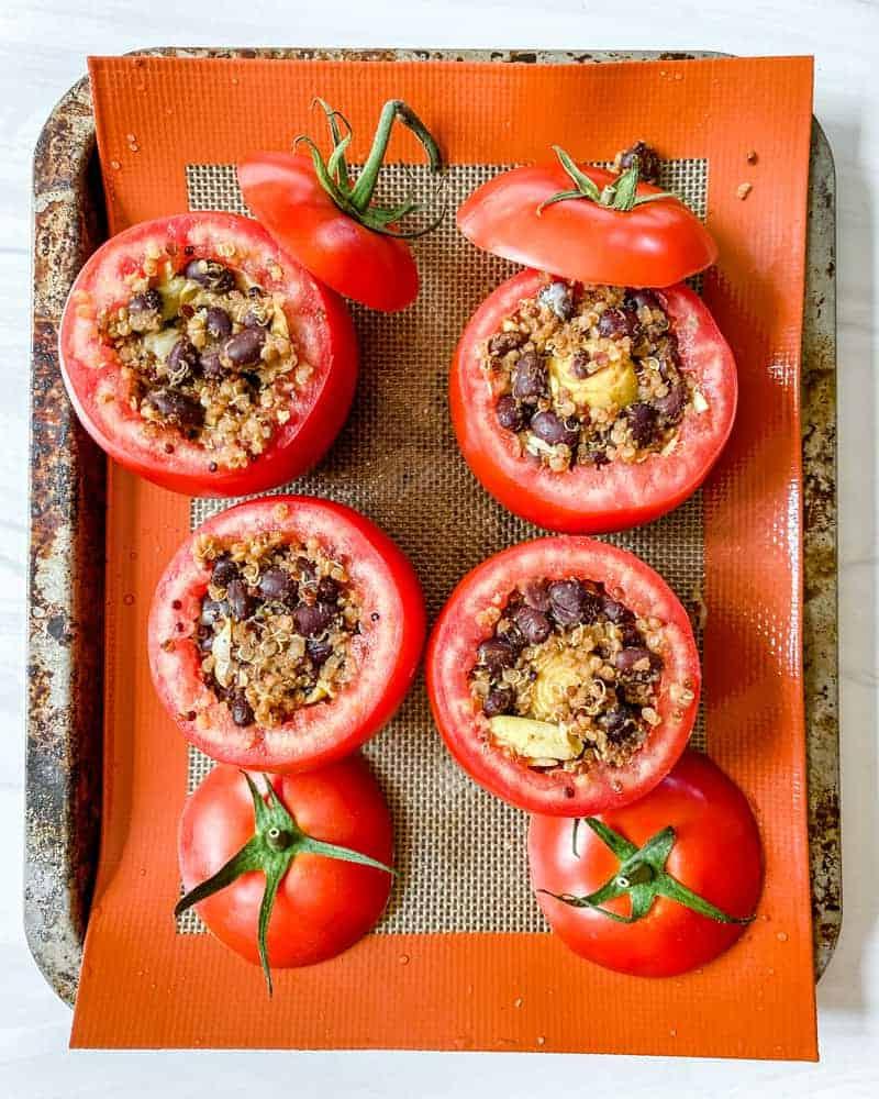 Gefüllte Tomaten 11 Vor dem Backen gefüllte Tomaten auf einer Silikonmatte auf einem Backblech