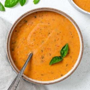Cremige geröstete rote Paprikasuppe 11 Fertige cremige geröstete rote Paprika Suppe in einer Schüssel auf hellem Untergrund