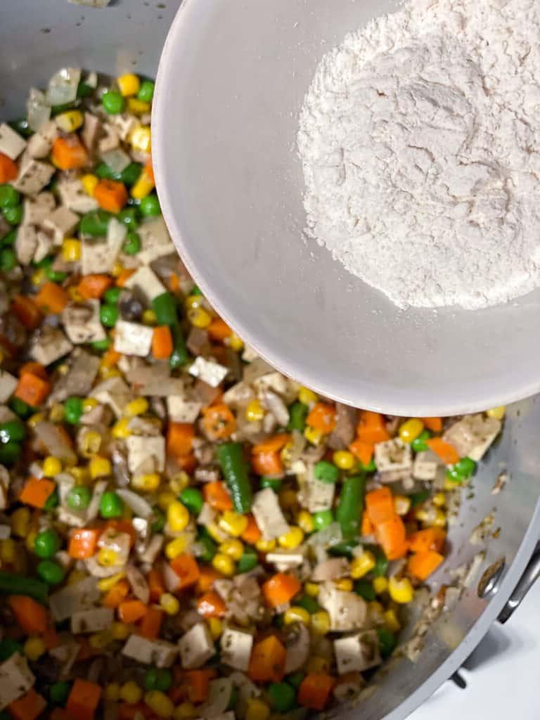 process shot of flour being added to pan