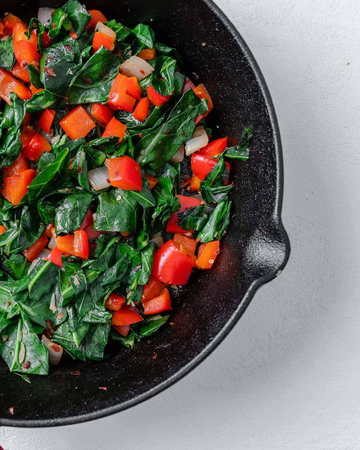 Scharfer Blattkohl 11 completed Spicy Collard Greens in a black pan against a white surface