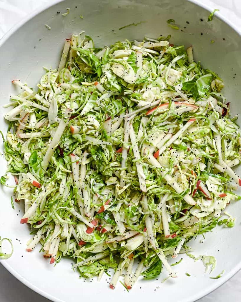 Gehobelter Rosenkohlsalat mit Äpfeln 11 Prozessaufnahme des Vermischens des geraspelten Rosenkohl-Krautsalats mit Äpfeln
