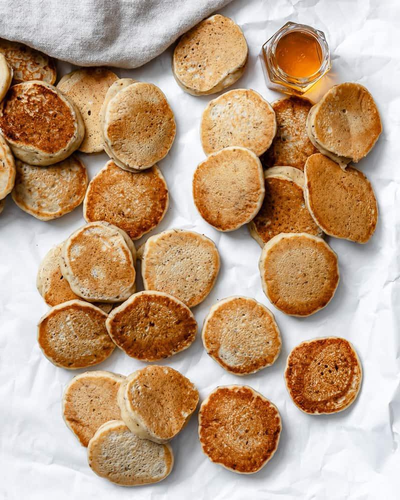 Mehrere fertige einfache vegane Pfannkuchen auf einer weißen Oberfläche
