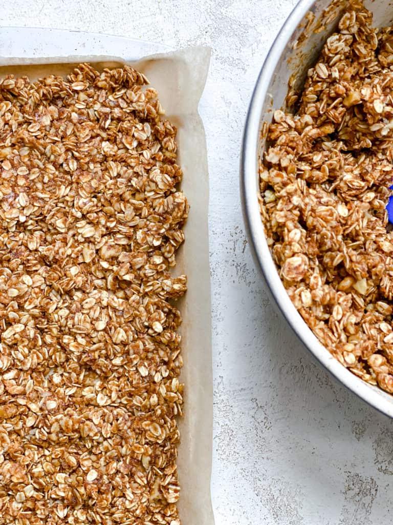 Einfaches Erdnussbutter Granola 11 process shot of adding peanut butter mixture to baking dish