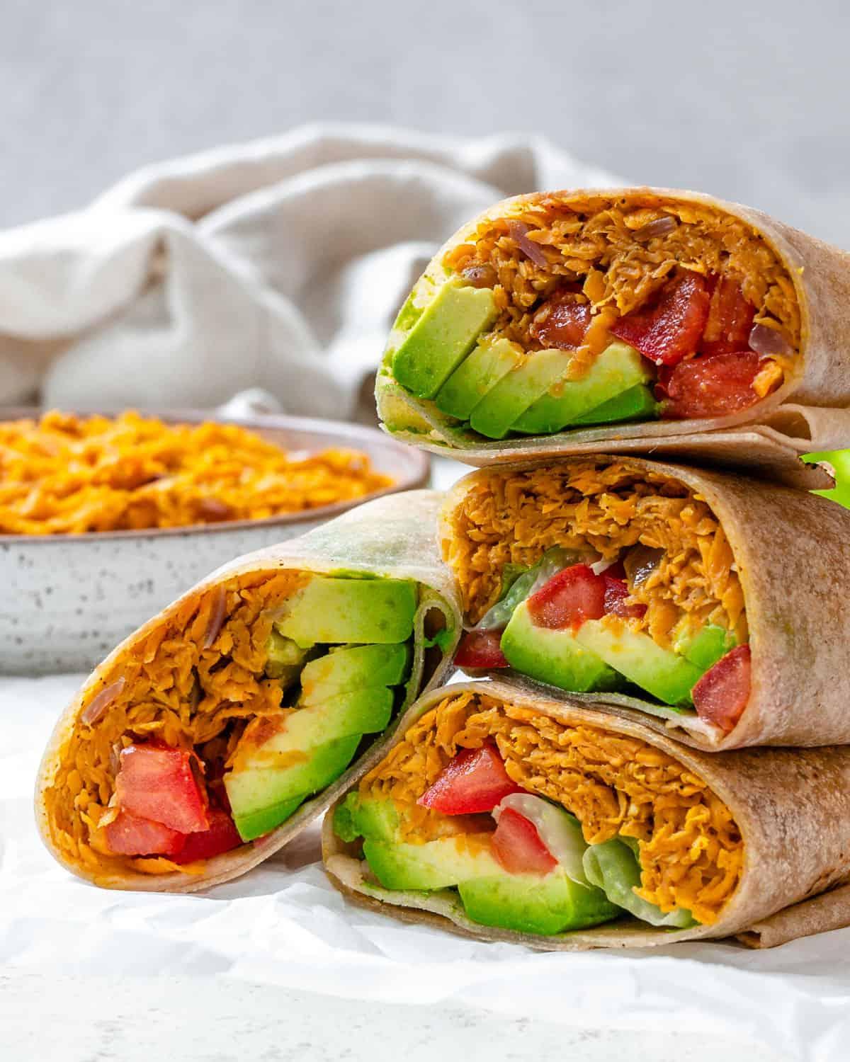 Süßkartoffel-Burritos 12 Fertig gestapelte Süßkartoffel Burritos vor hellem Hintergrund