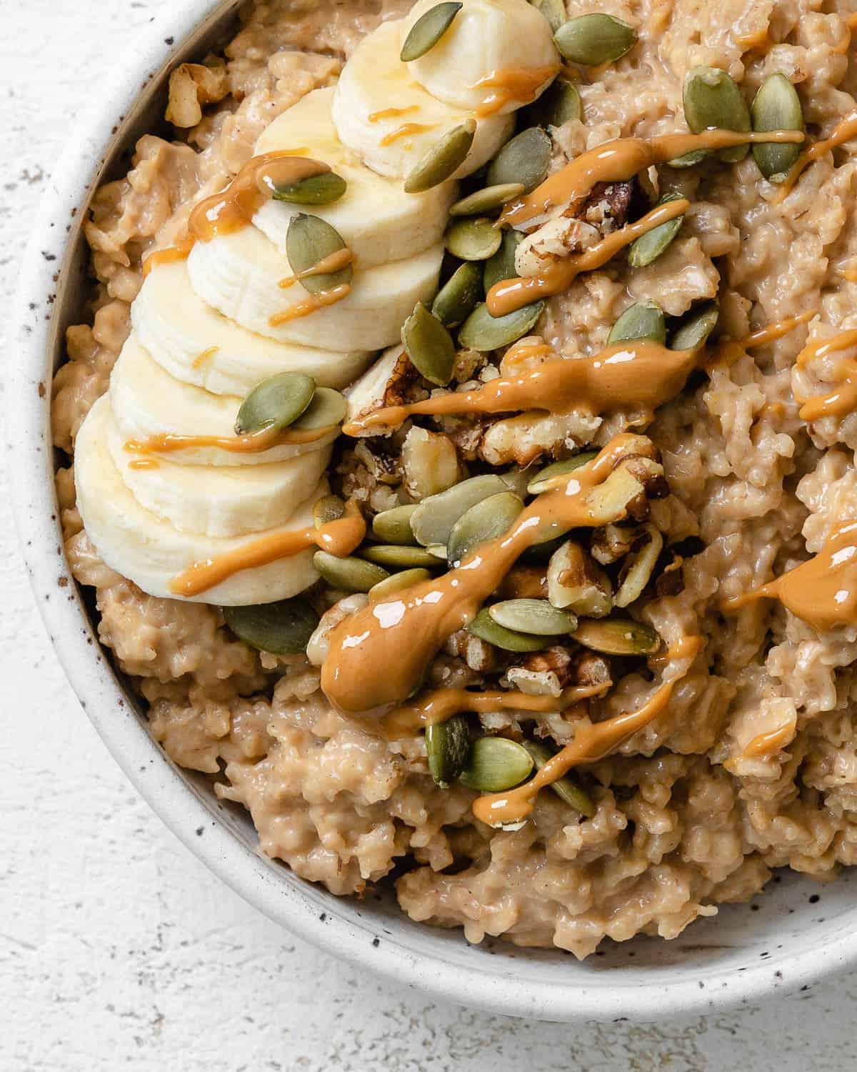 Einfacher Erdnussbutter-Porridge (+ Extras) 12 completed Easy Peanut Butter Oatmeal in a bowl against a light background