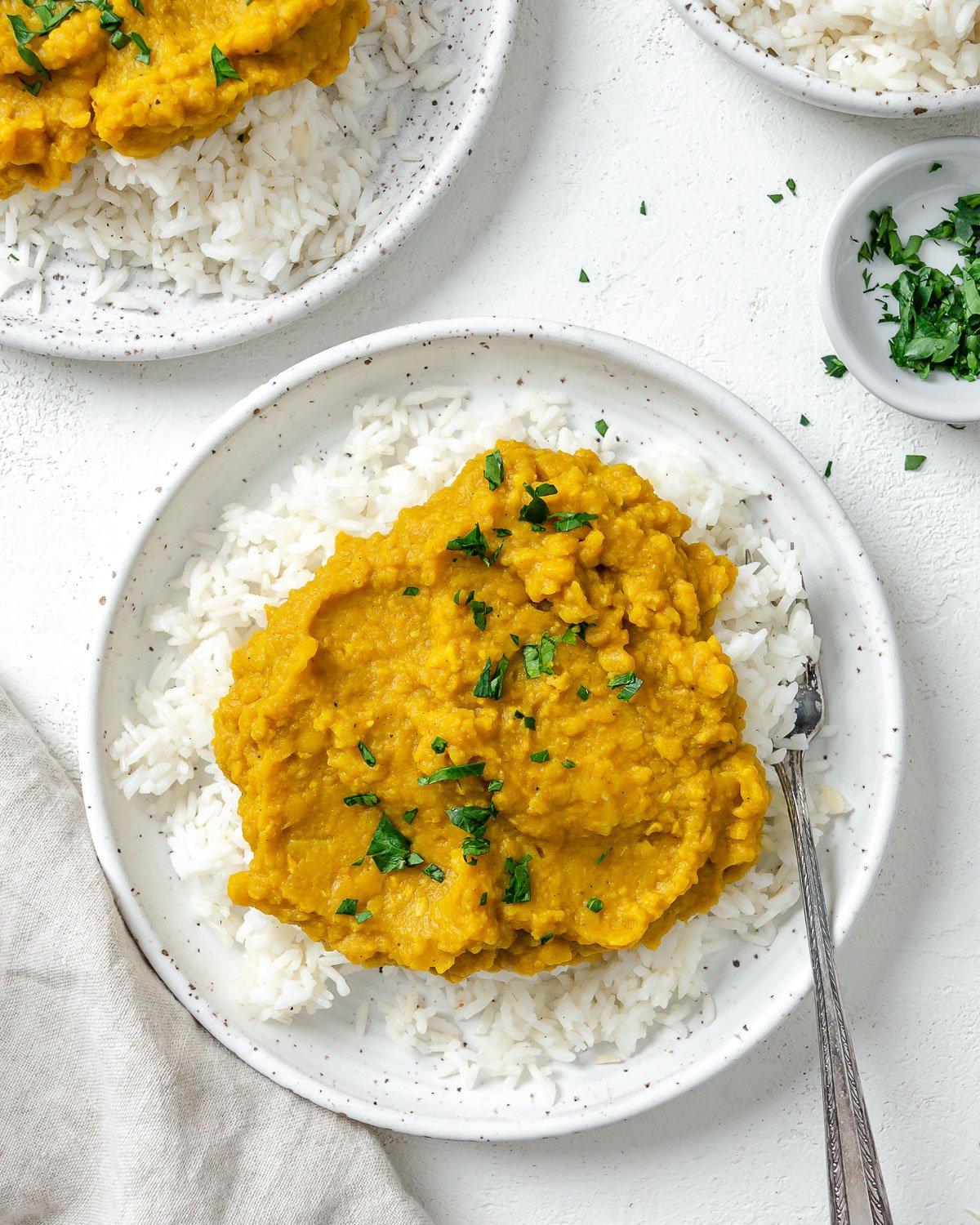 Einfaches gelbes Dal-Rezept 12 Fertiges einfaches gelbes Dal auf Reis in einem weißen Teller vor hellem Hintergrund