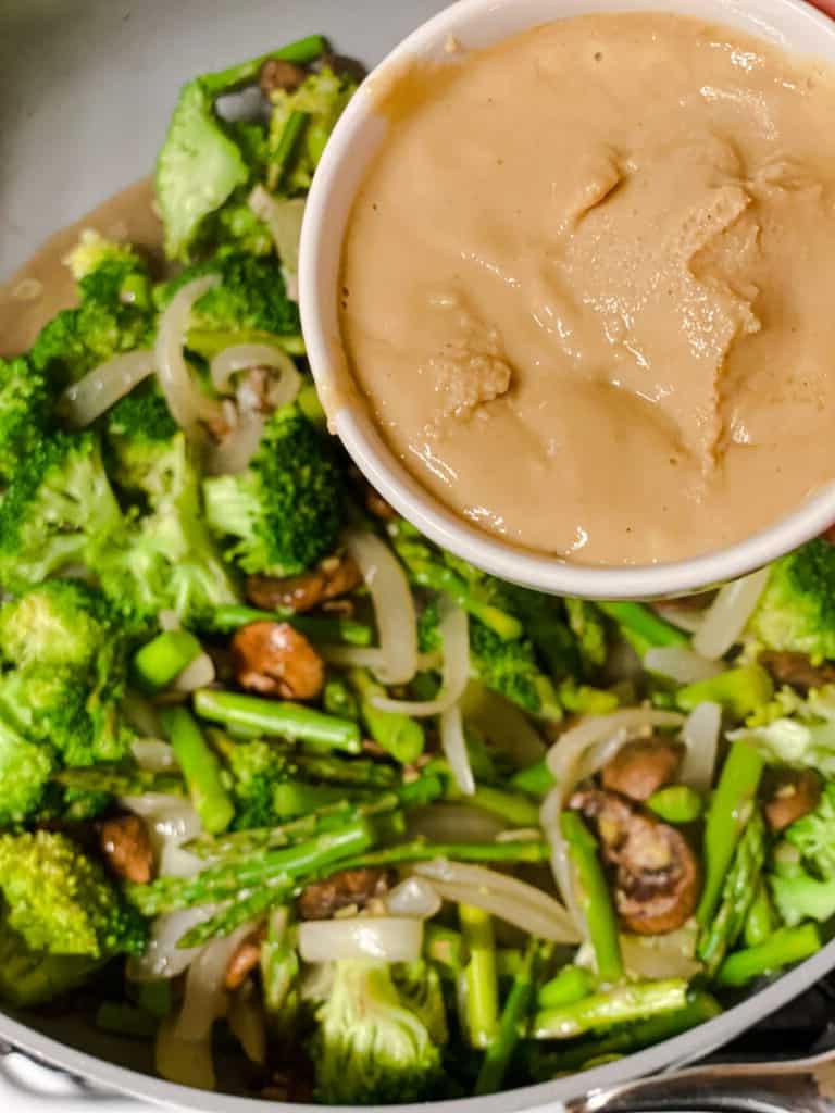 Cremige Reisnudelpfanne 12 Tahini wird in die Pfanne gegeben