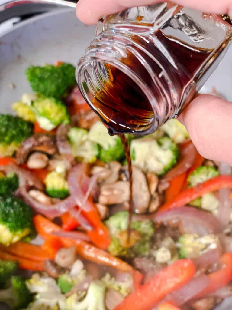Gesunder Gerösteter Kartoffelsalat 13 Prozessaufnahme: Balsamico-Essig wird über das angebratene Gemüse in der Pfanne geträufelt