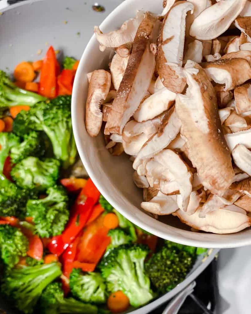 Einfaches Wok-Gemüse 13 Prozessaufnahme des Hinzufügens von Pilzen zur Pfanne