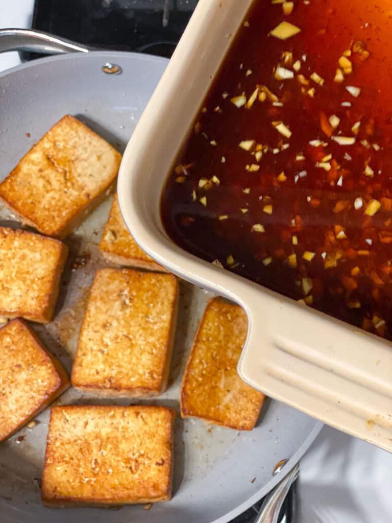 Einfaches Tofu Adobo 13 process shot showing marinade being added to tofu in skillet
