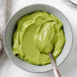 Einfacher Avocado-Aufstrich 13 Fertiger cremiger Avocado-Aufstrich in einer Schale vor hellem Hintergrund
