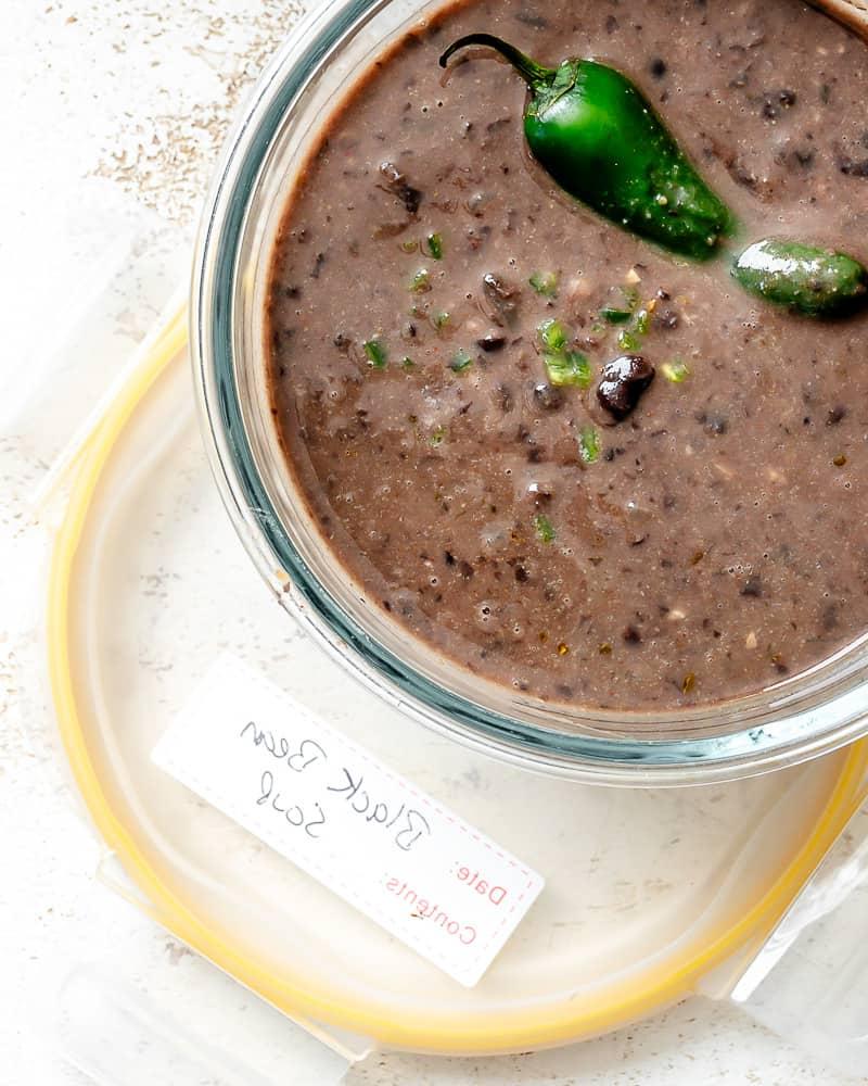 Schwarze Bohnensuppe 13 Eine Portion schwarze Bohnensuppe in einem Glasbehälter zur Aufbewahrung.