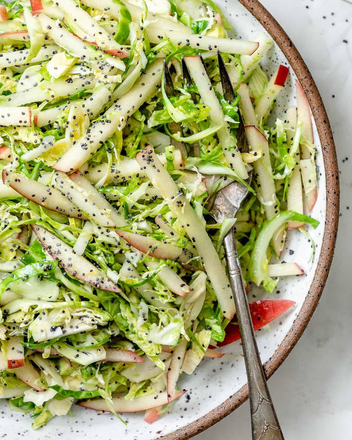 Gehobelter Rosenkohlsalat mit Äpfeln 13 Fertiger Rosenkohl-Krautsalat mit Äpfeln in einer Schüssel