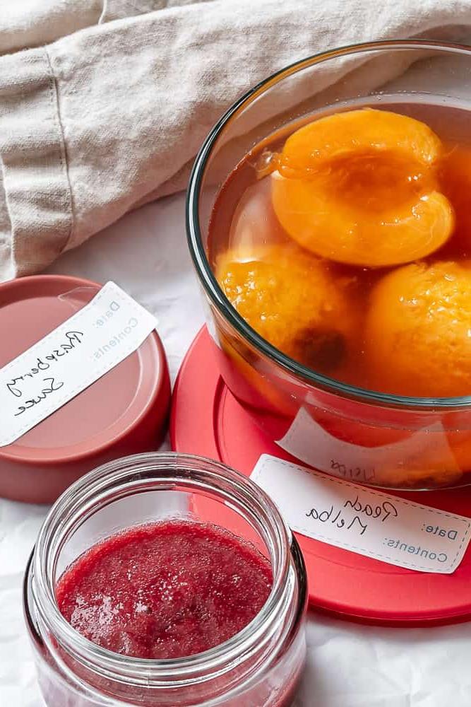 Peach Melba 14 Übrig gebliebene pochierte Pfirsiche und Himbeersauce in einzelnen Aufbewahrungsbehältern.
