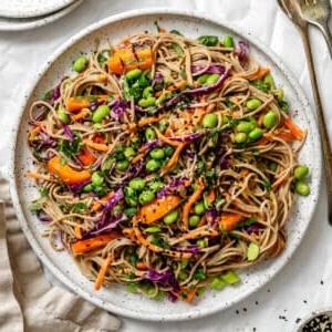 soba noodle salad on a large white serving plate.