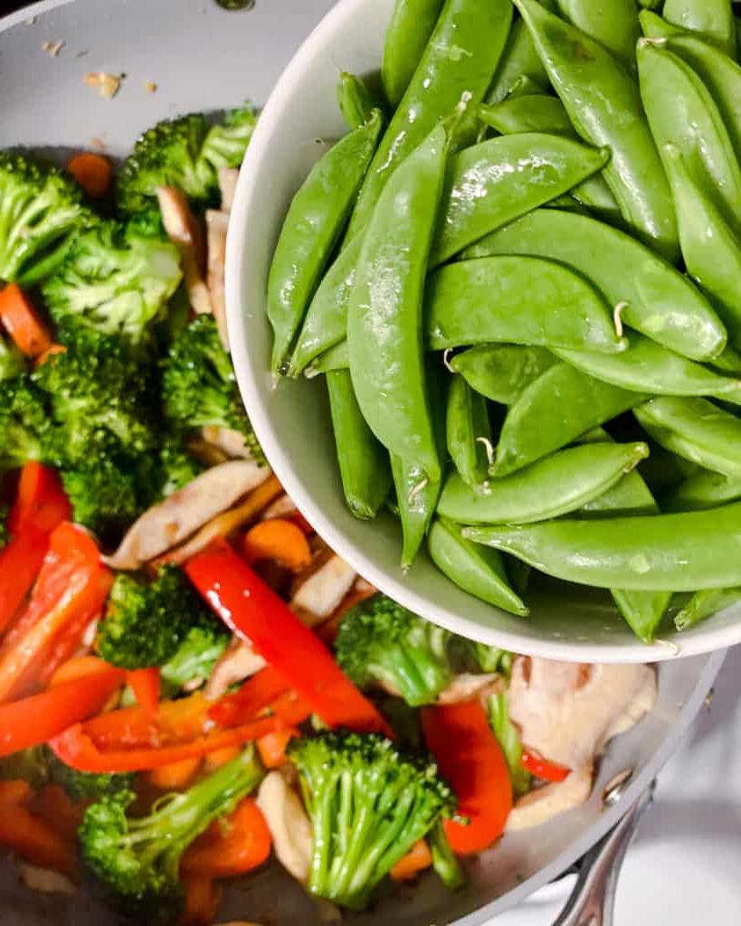 Einfaches Wok-Gemüse 15 Prozessaufnahme des Hinzufügens von Zuckerschoten zur Pfanne