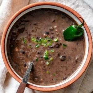 Schwarze Bohnensuppe 15 Nahaufnahme von schwarzer Bohnensuppe mit gewürfelten Jalapeños in einer Schüssel.