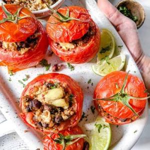 Gefüllte Tomaten 16 Fertige gefüllte Tomaten auf einem weißen Teller vor weißem Hintergrund