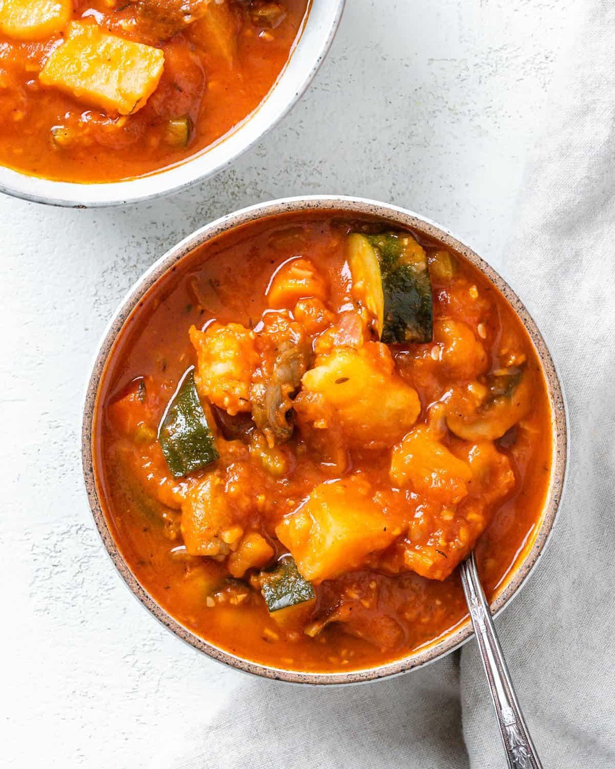 30 einfache vegane Kartoffelrezepte 16 Fertige Tomatensuppe mit Kartoffeln auf einer weißen Oberfläche