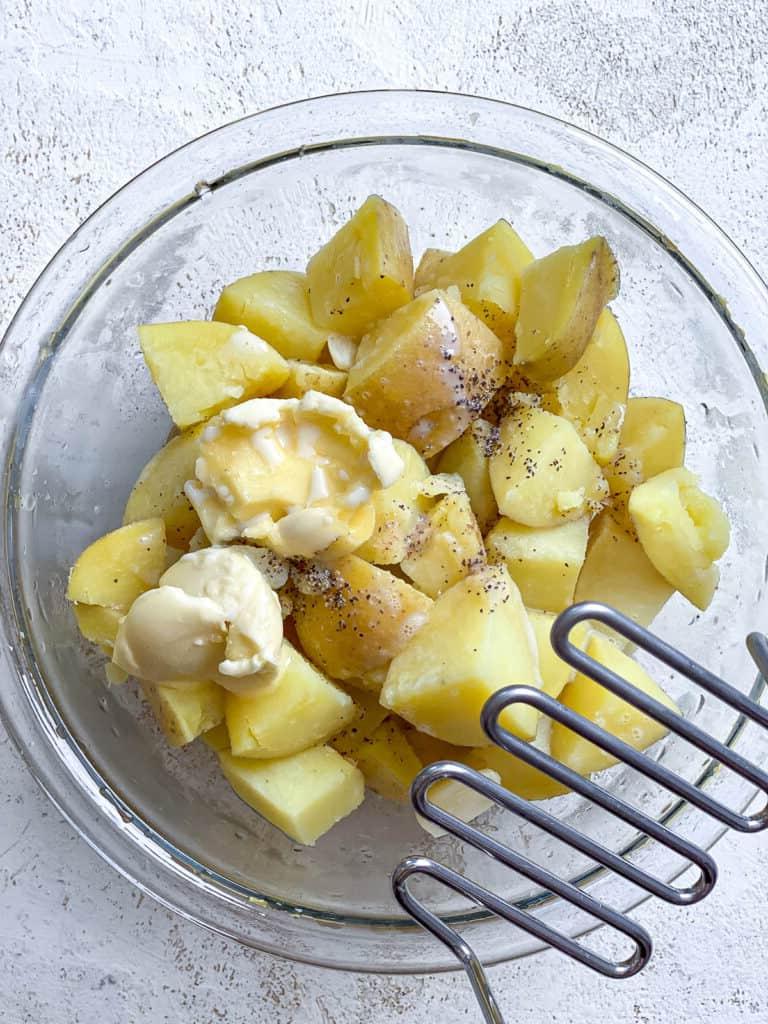 Veganer Linsen-Hirtenkuchen 16 Gekochte Kartoffeln und vegane Butter in einer Schüssel, bereit zum Stampfen