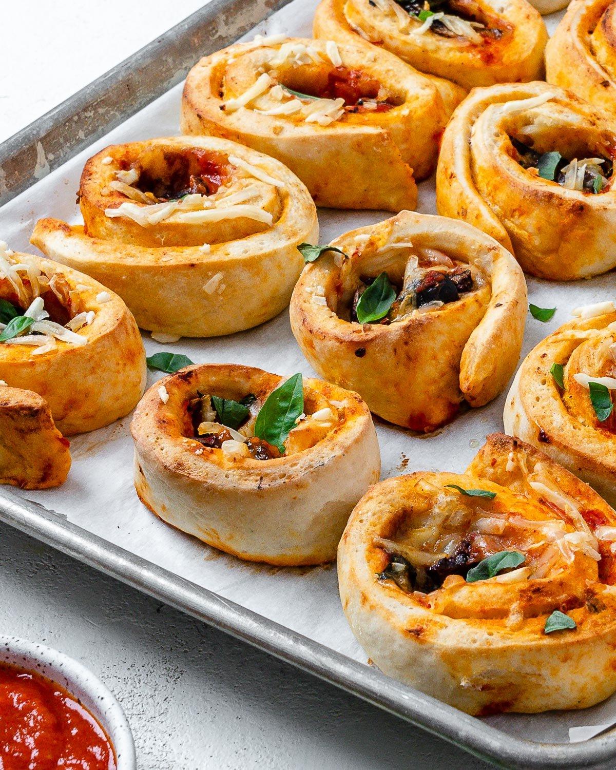 Vegane Pizzaröllchen 16 several completed vegan pizza rolls on a baking dish