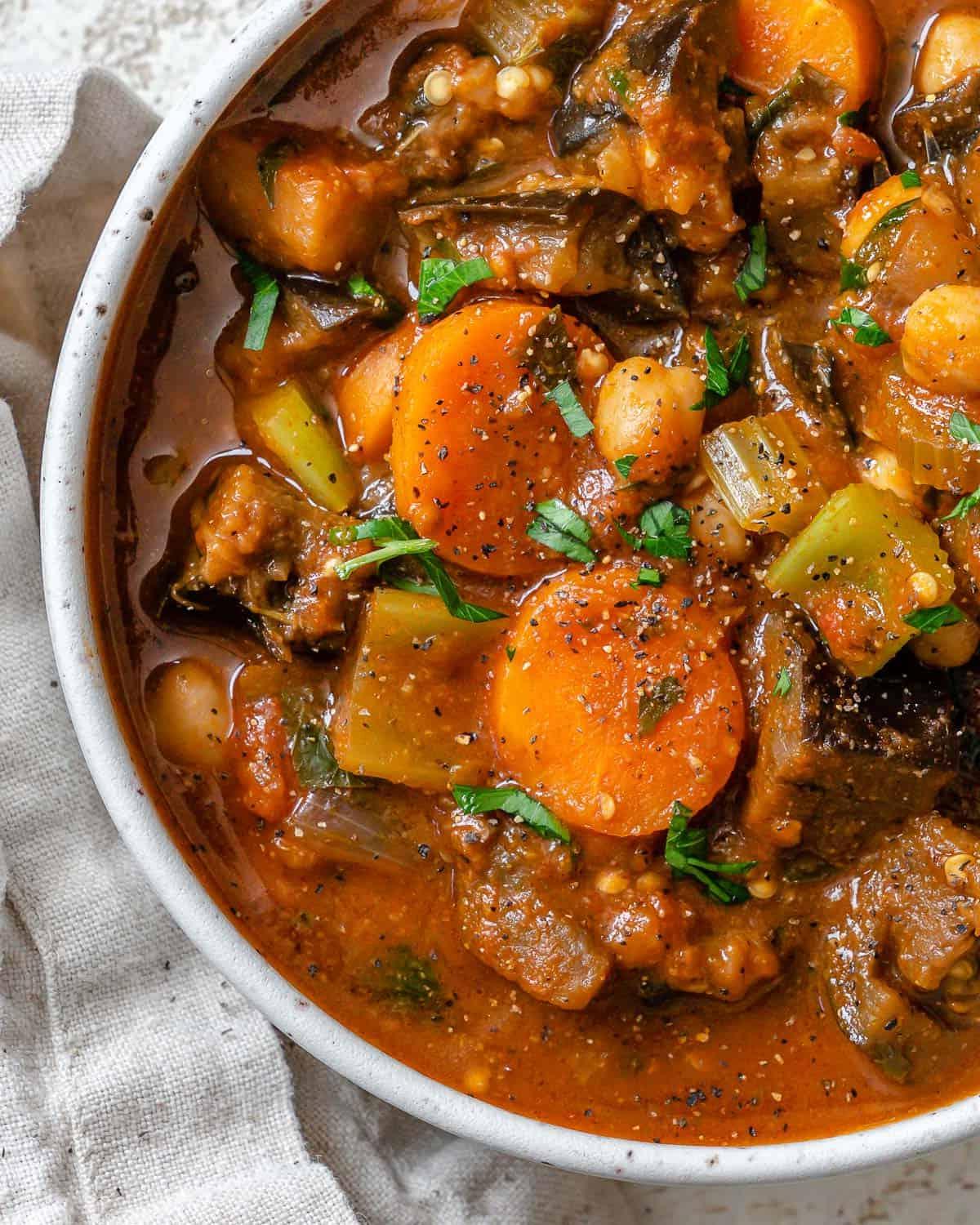 Fertig gestellter Auberginen-Eintopf mit Tomaten und Kichererbsen auf einer weißen Oberfläche