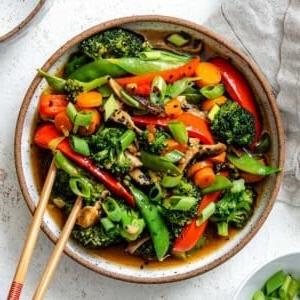 Einfaches Wok-Gemüse 19 Fertiges einfaches Stir-Fry Gemüse in einer Schüssel vor hellem Hintergrund
