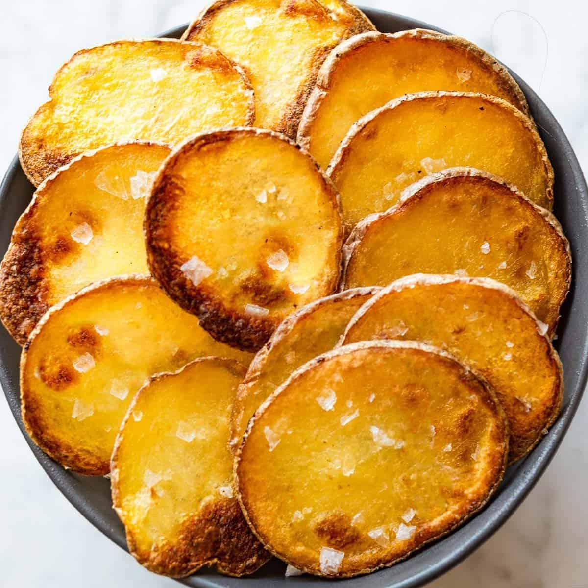 30 einfache vegane Kartoffelrezepte 19 Fertige Hausgemachte Kartoffelchips auf einer weißen Oberfläche