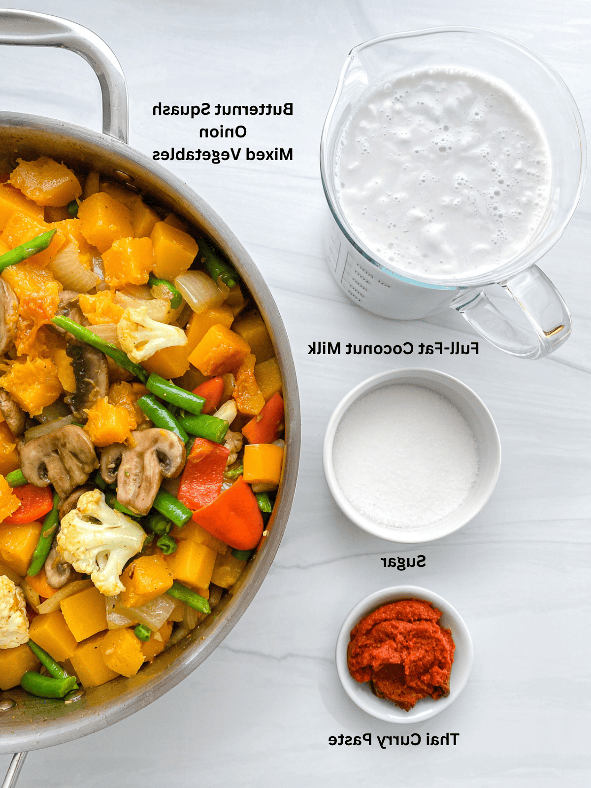 Zutaten für Butternut-Kürbis-Curry auf weißer Oberfläche abgemessen