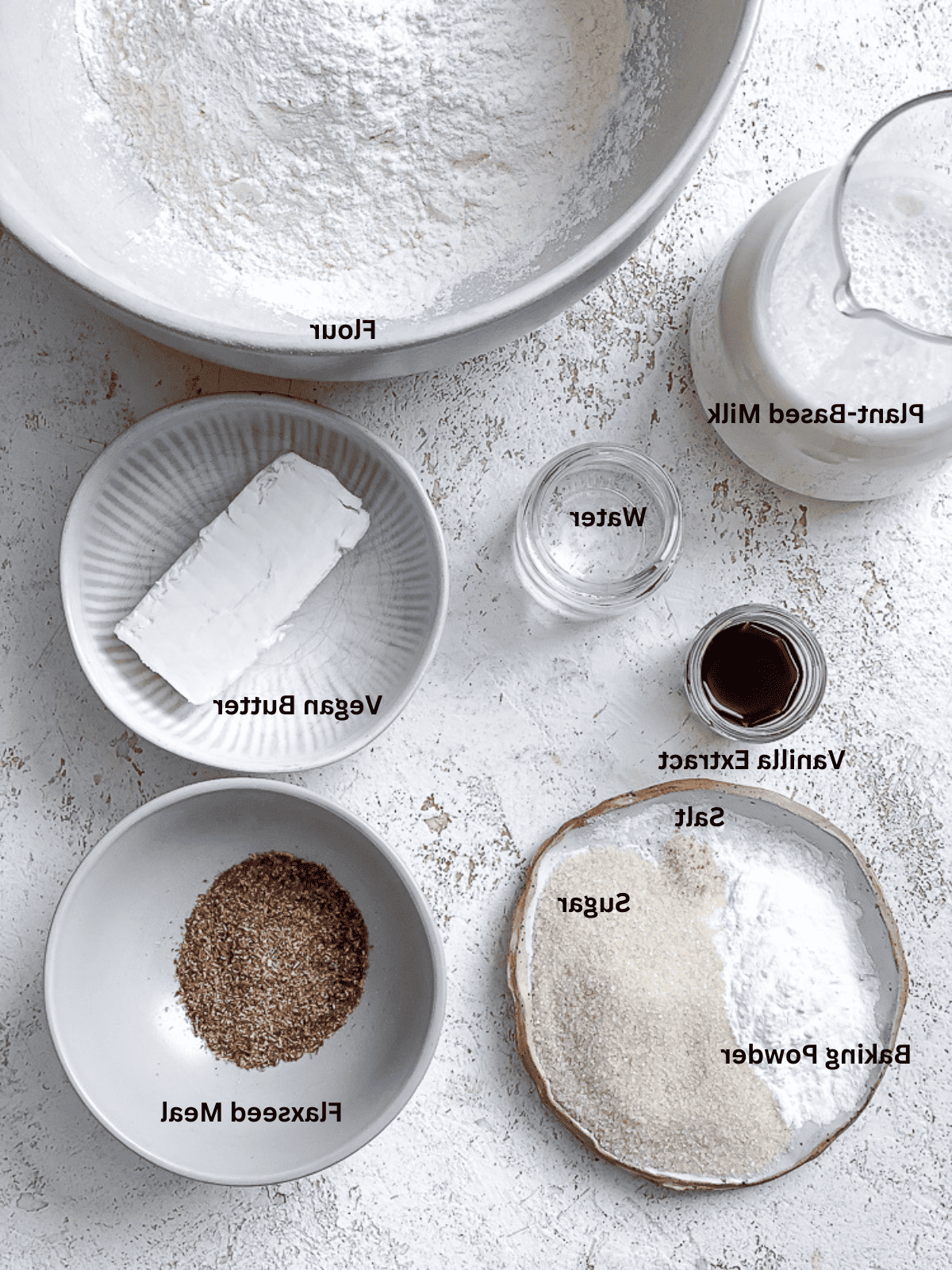 Zutaten für einfache vegane Pfannkuchen auf einer weißen Oberfläche vorbereitet